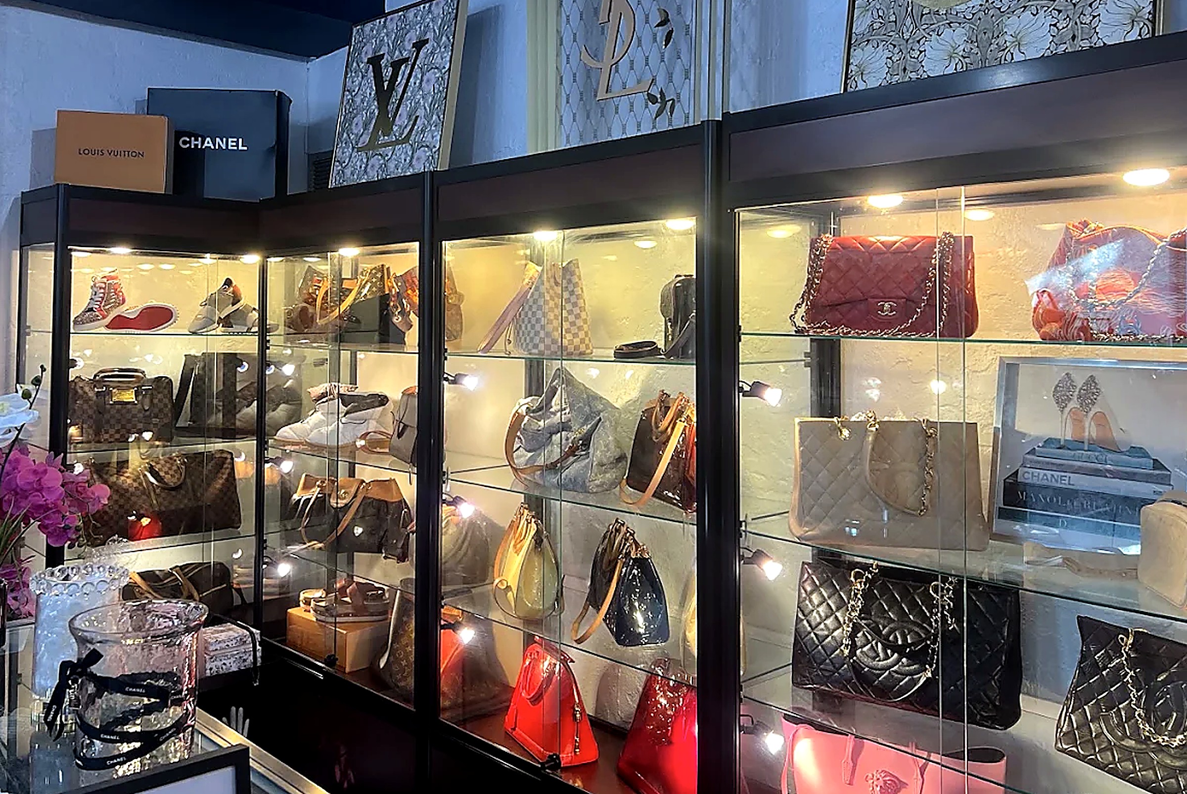 Designer handbags on lit display at Love, Fashion & More